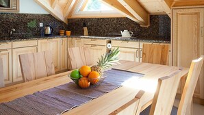 A kitchen with wooden cabinets, a stone backsplash, and a skylight. - Edelweiss A by Interhome (Leukerbad)