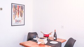A dining table with a bottle of wine, a glass, and a basket of bread. - Haus Bellevue by Interhome (Zermatt)
