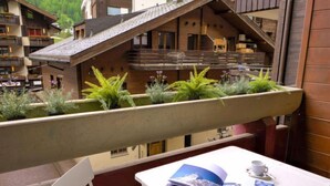 A balcony with a table, a book, and a cup. - Haus Bellevue by Interhome (Zermatt)
