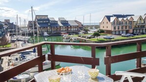 A marina with boats, a dining table with food, and a view of buildings across the water.
