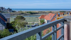 A coastal residential area with a view of the sea, featuring houses with red-tiled roofs and a clear sky. - Port Guillaume by Interhome (Cabourg)