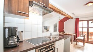 Eine moderne Küche mit Einbauherd, Backofen und Kaffeemaschine.