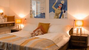 A hotel room with a bed, two nightstands, and two wall-mounted lamps. - Chesa Ova Cotschna 205 by Interhome (St. Moritz)