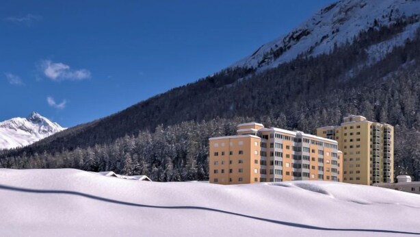 A hotel with multiple floors, surrounded by snow-covered mountains and a clear blue sky. - Chesa Ova Cotschna 205 by Interhome (St. Moritz)