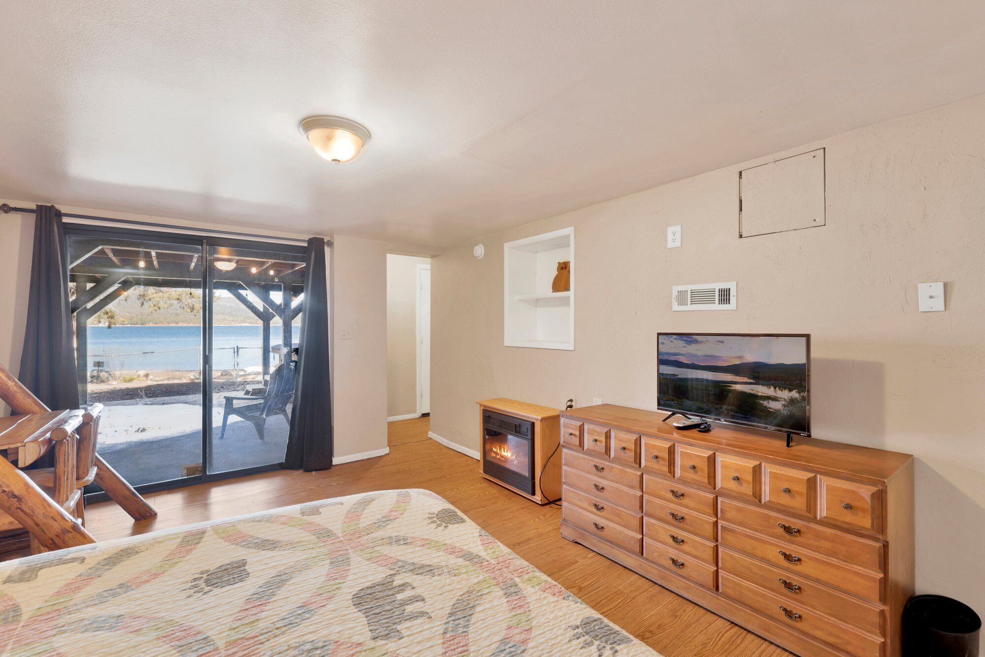 Een kamer met een houten dressoir, een televisie en een open haard.