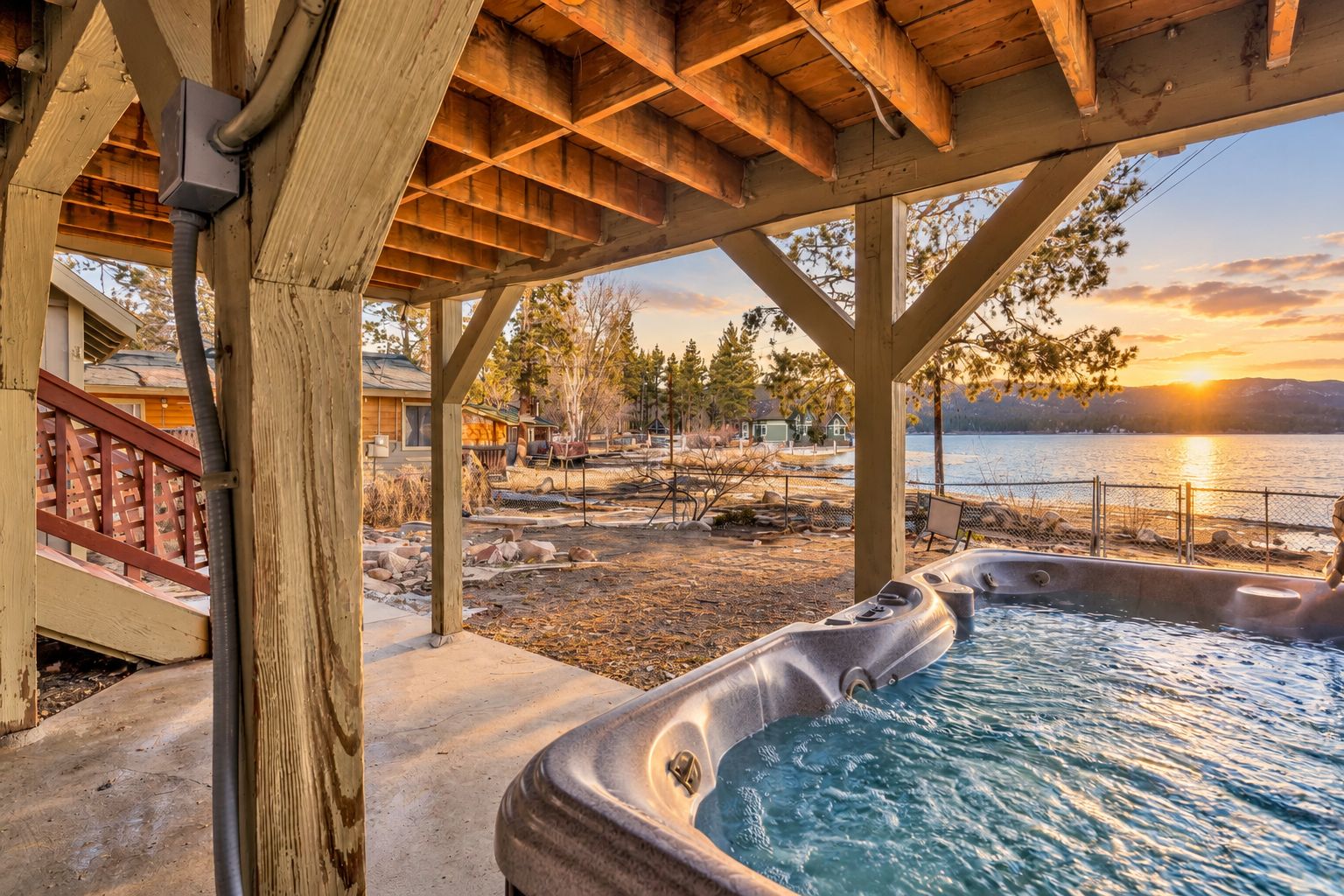 A hot tub area with a view of a lake and sunset.