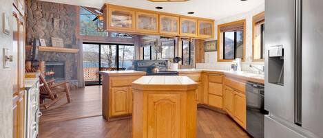 Una cocina amplia con armarios de madera, una isla central y un refrigerador grande.