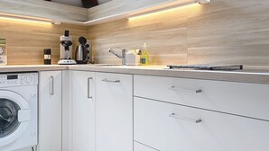 Una cocina moderna con lavadora incorporada, vigas de madera y tragaluces.