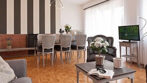 Un salon moderne comprenant un coin repas, un téléviseur et une cheminée.