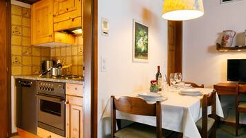 Een koelkast, een oven, een vaatwasser, kookgerei, borden en bestek