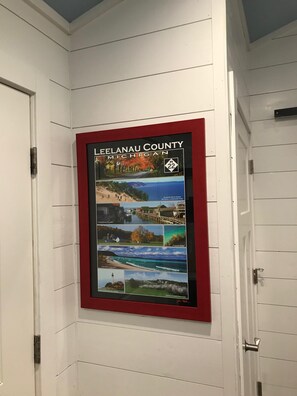 A framed poster of Leelanau County, Michigan, featuring various local attractions. - Cute cabin in our private woods, close to a bike trail, winery, and lakes (Traverse City)