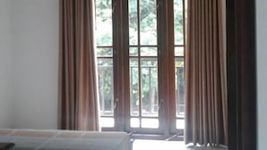 A room with a bed, a window with curtains, and an air conditioning unit. - White House Holiday Home (Maspotha)