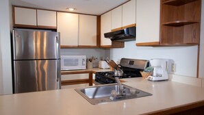 A modern kitchen with stainless steel appliances, a microwave, a stove, and a sink. - Ski-In/Ski-Out Condo with Access to Indoor Pool (Ludlow)