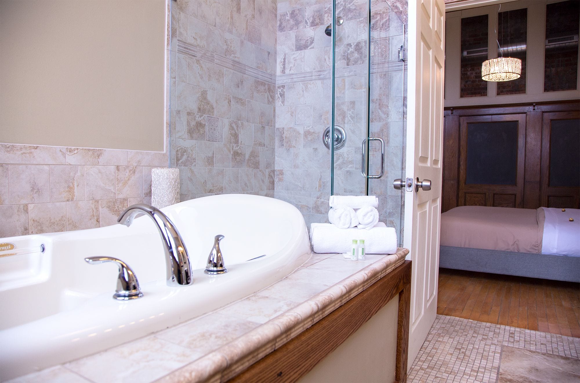 Une salle de bain avec une grande baignoire blanche, une douche en verre et un meuble-lavabo en bois.