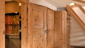 A room with wooden cabinets, a staircase, and a wooden floor.