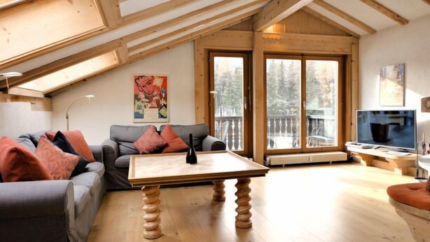 A cozy living room with a wooden ceiling, a sofa, a coffee table, and a TV.