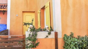 A yellow door with a small window above it, a white wall, and a wooden staircase leading up. - Plein Sud by Interhome (Narbonne-Plage)
