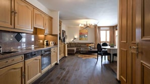 Une cuisine spacieuse dotée de meubles en bois, d’un four encastré et d’un coin repas avec une table et des chaises.