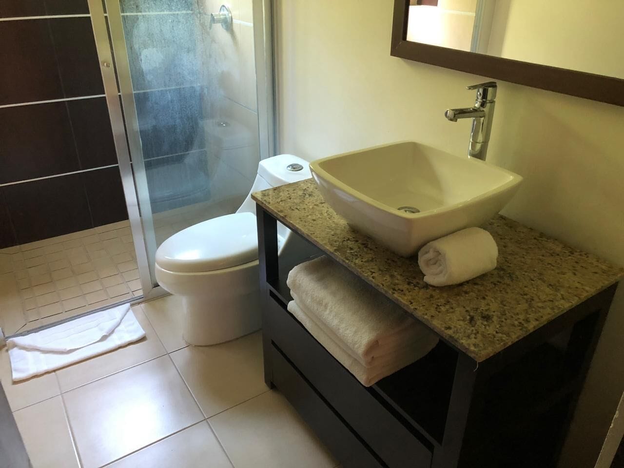Ein Badezimmer mit einem weißen Waschbecken, einem Handtuch und einer Toilette.