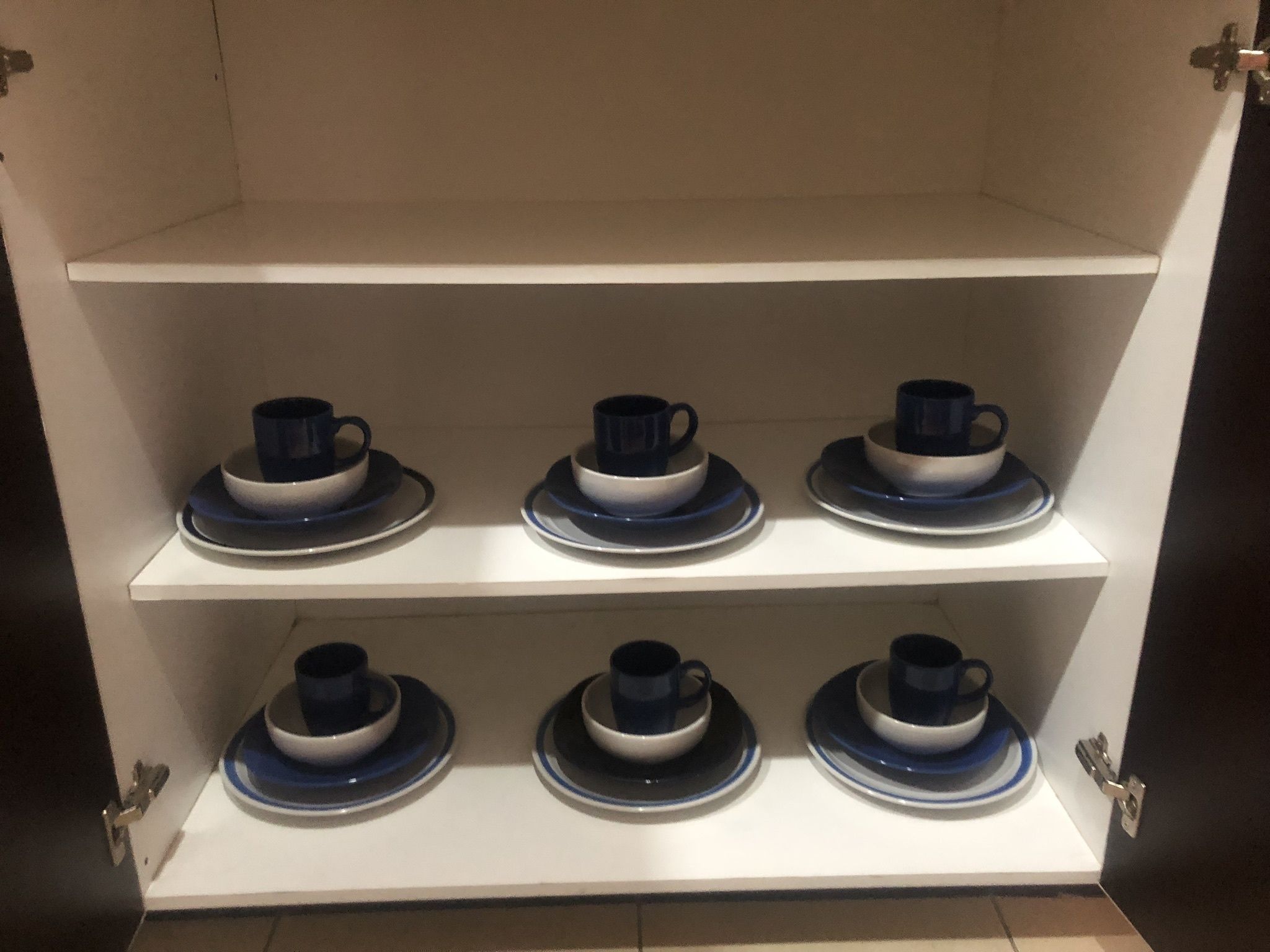 A display shelf with six sets of blue and white cups and saucers.