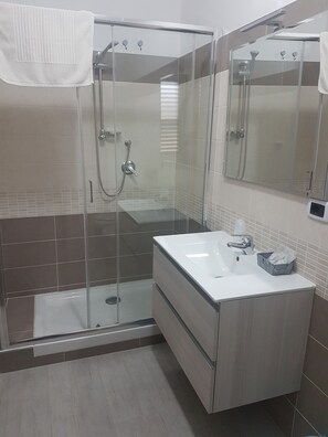 Superior vierpersoonskamer | Badkamer | Een douche, gratis toiletartikelen, een haardroger, badjassen