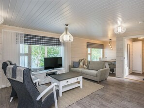 A modern living room with a television, sofa, and a dining area. - Tähtiranta by Interhome (Valkeala)
