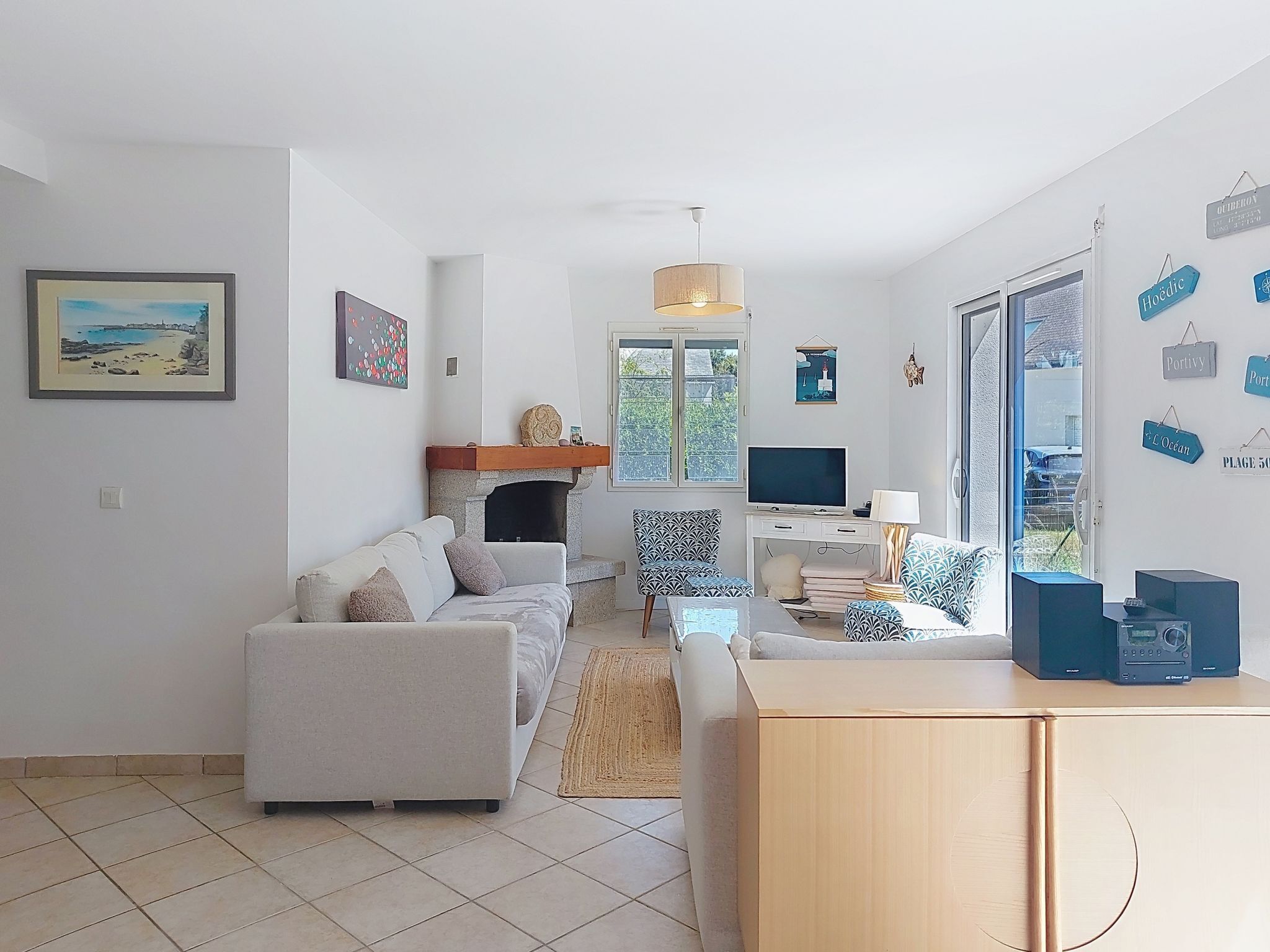 Un salon avec une cheminée, un canapé, un téléviseur et un bureau avec un ordinateur.