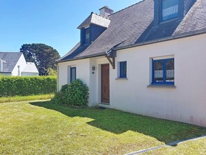 A house with a sloped roof, a small front porch, and a well-maintained lawn.