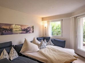 A room with a bed, a sofa, and a painting on the wall. - Chesa Flora 53 by Interhome (St. Moritz)