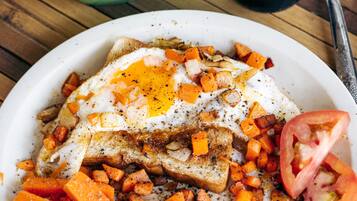 Un plato de desayuno con huevos, tostadas y verduras en cubos.
