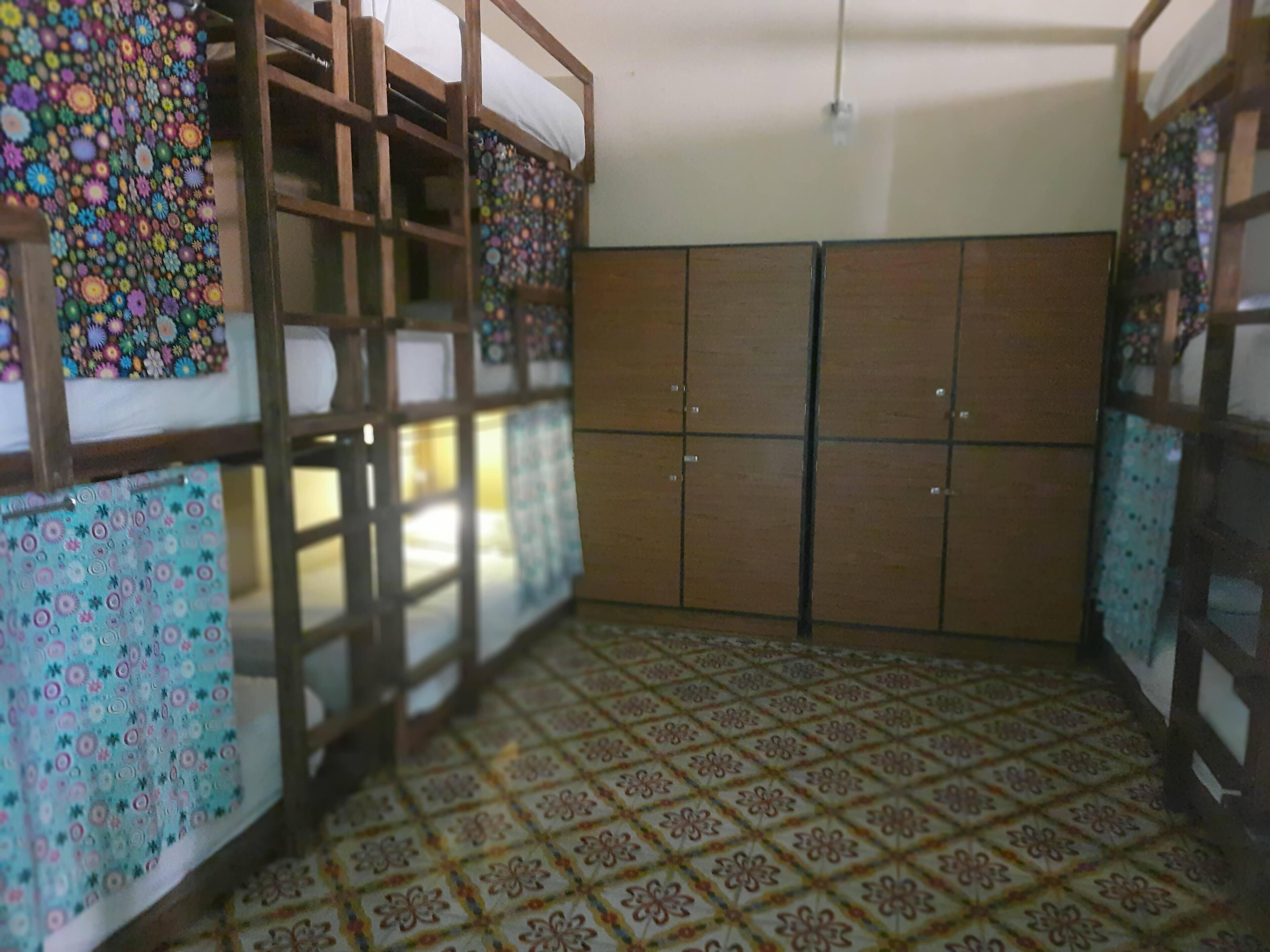 Ein Zimmer mit Etagenbett, Kleiderschrank und Fliesenboden.