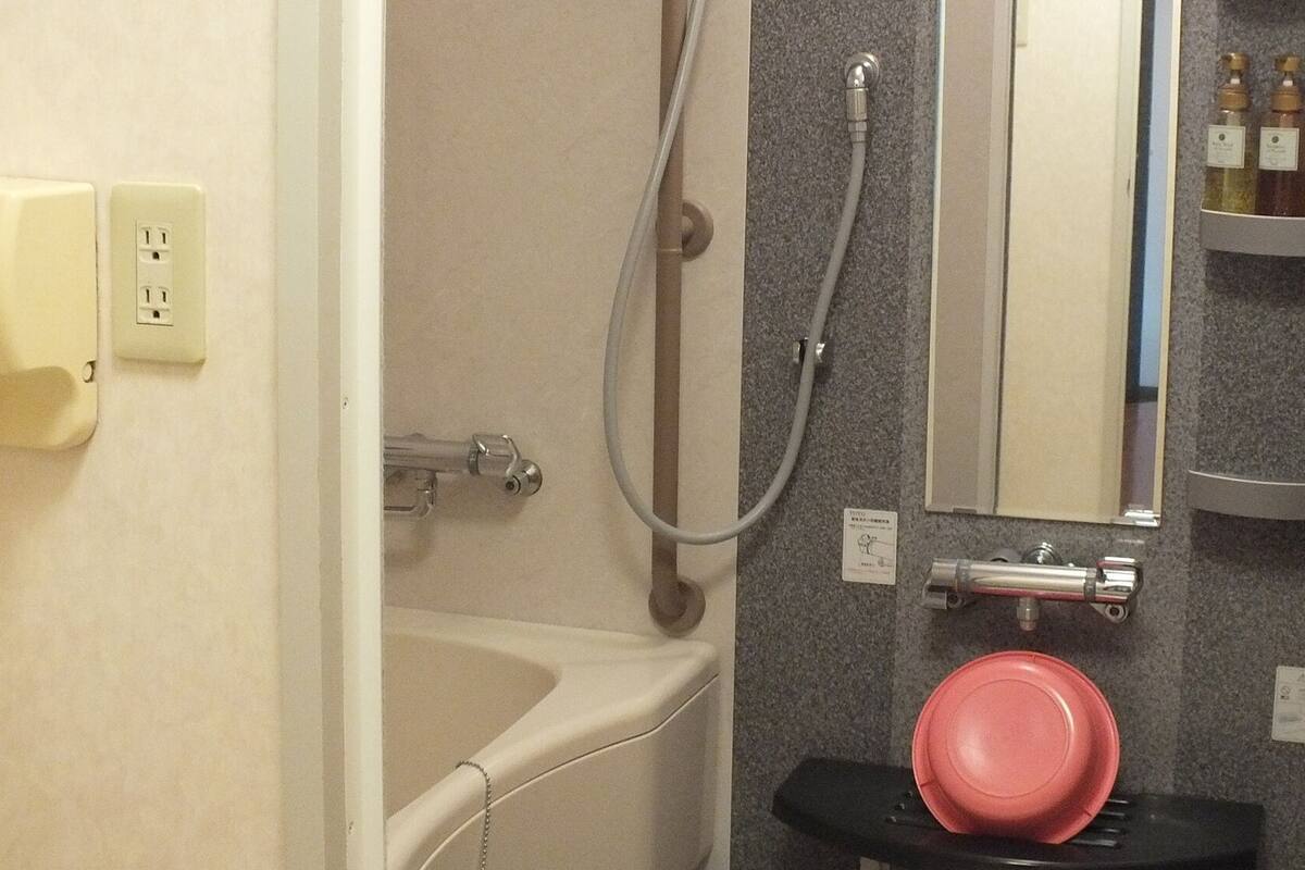 Un baño con bañera, ducha, lavabo y espejo.
