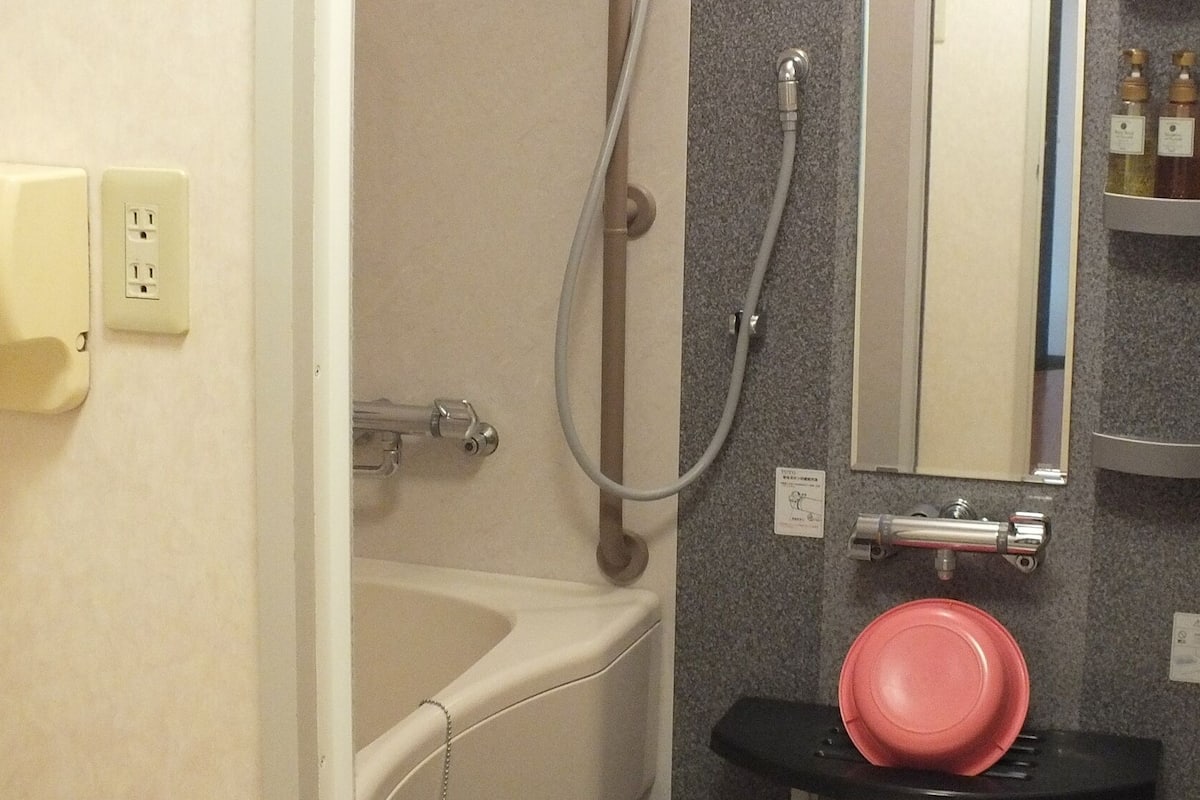 Un baño con bañera, ducha, lavabo y espejo.
