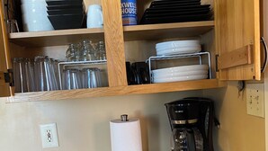 Una cocina con armarios de madera, una cafetera y un dispensador de toallas de papel.