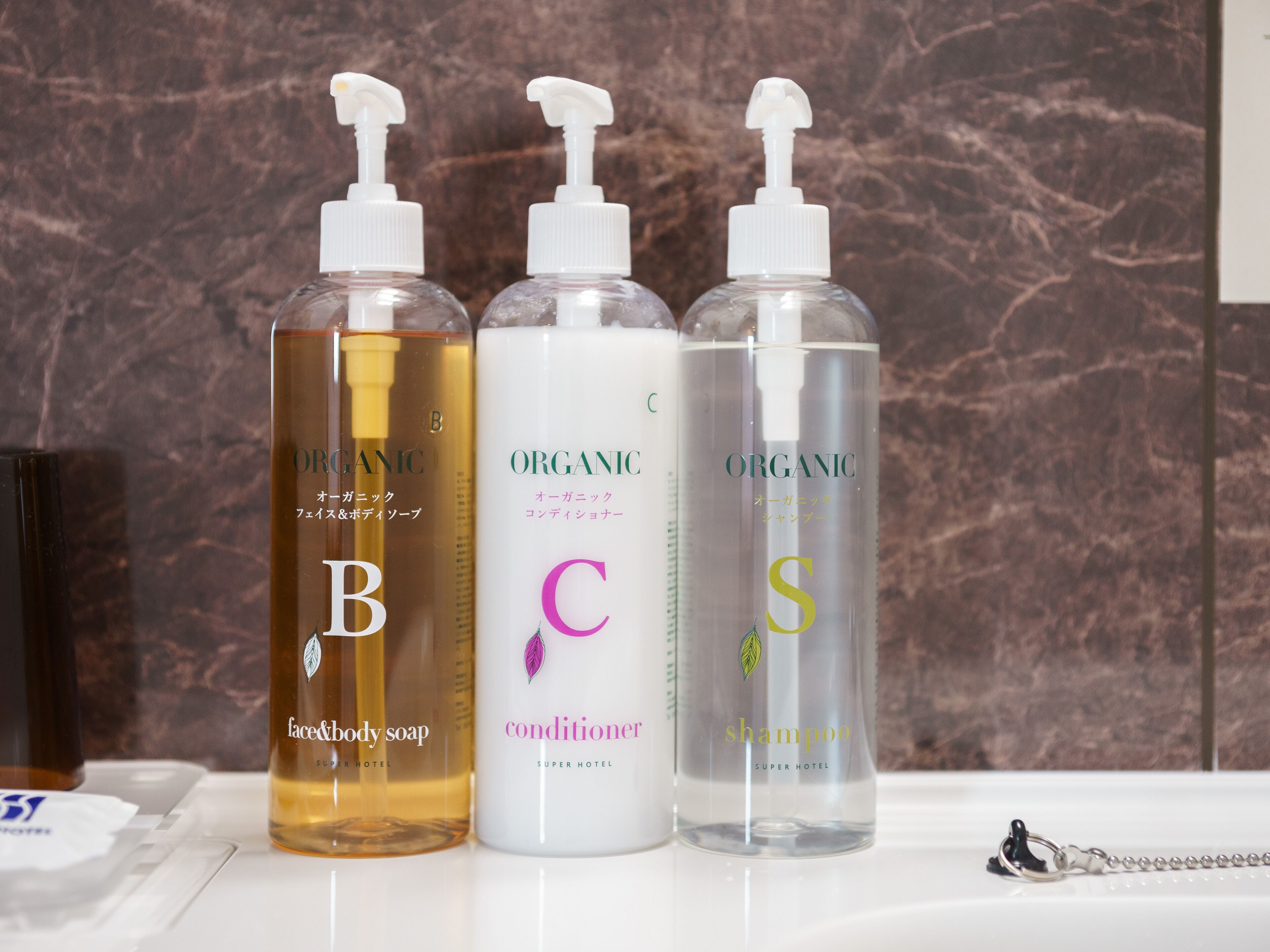 Trois flacons de produits de soins personnels biologiques sont posés sur le comptoir d’une salle de bain.