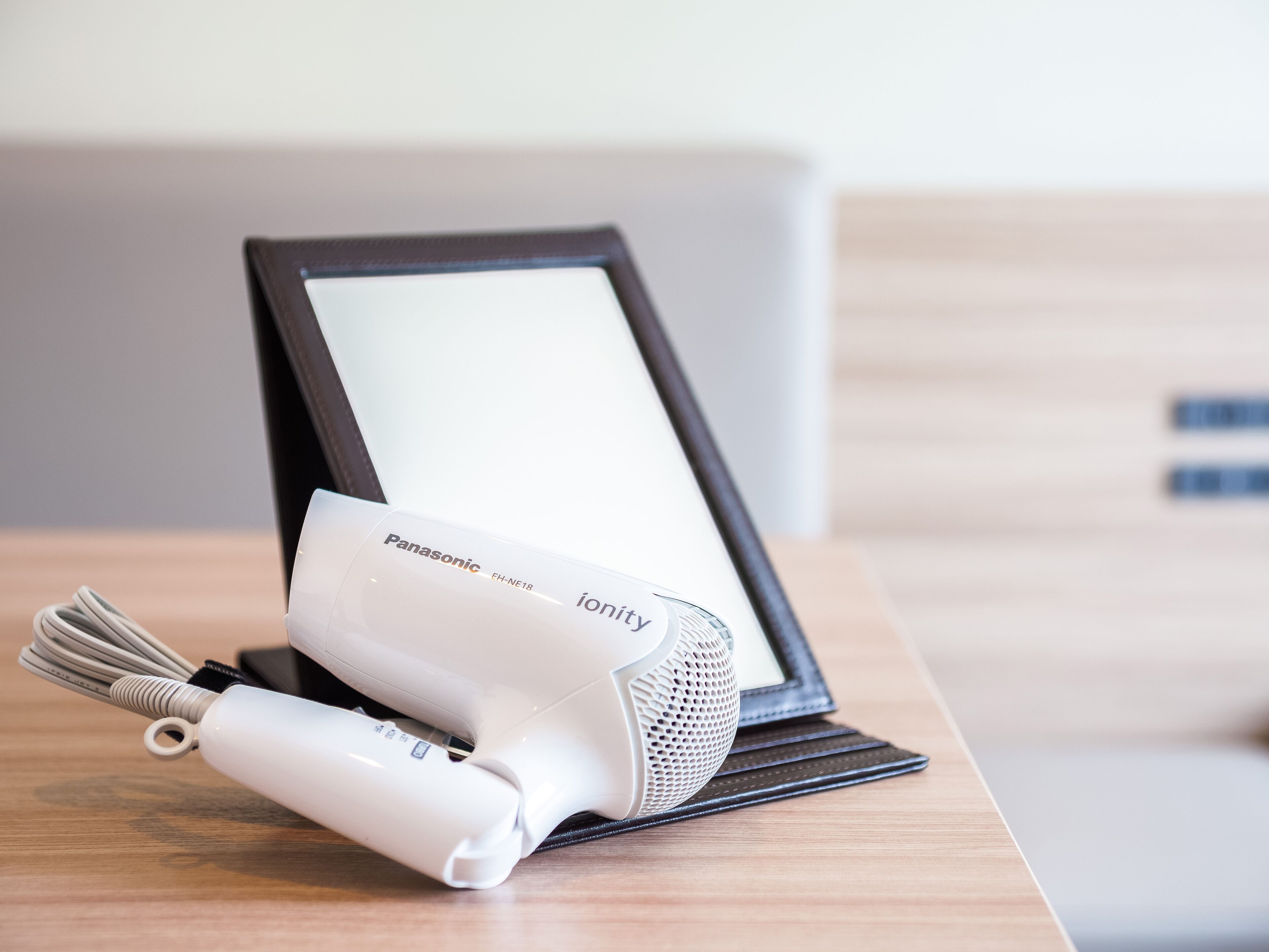 A Panasonic ionify hair dryer on a wooden table.