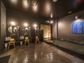 Un bagno moderno con diverse cabine doccia, uno specchio grande e una zona sauna.