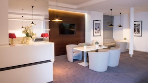 A modern hotel lobby with a reception desk, seating area, and a television mounted on the wall. - Hotel Maraton (Bydgoszcz)