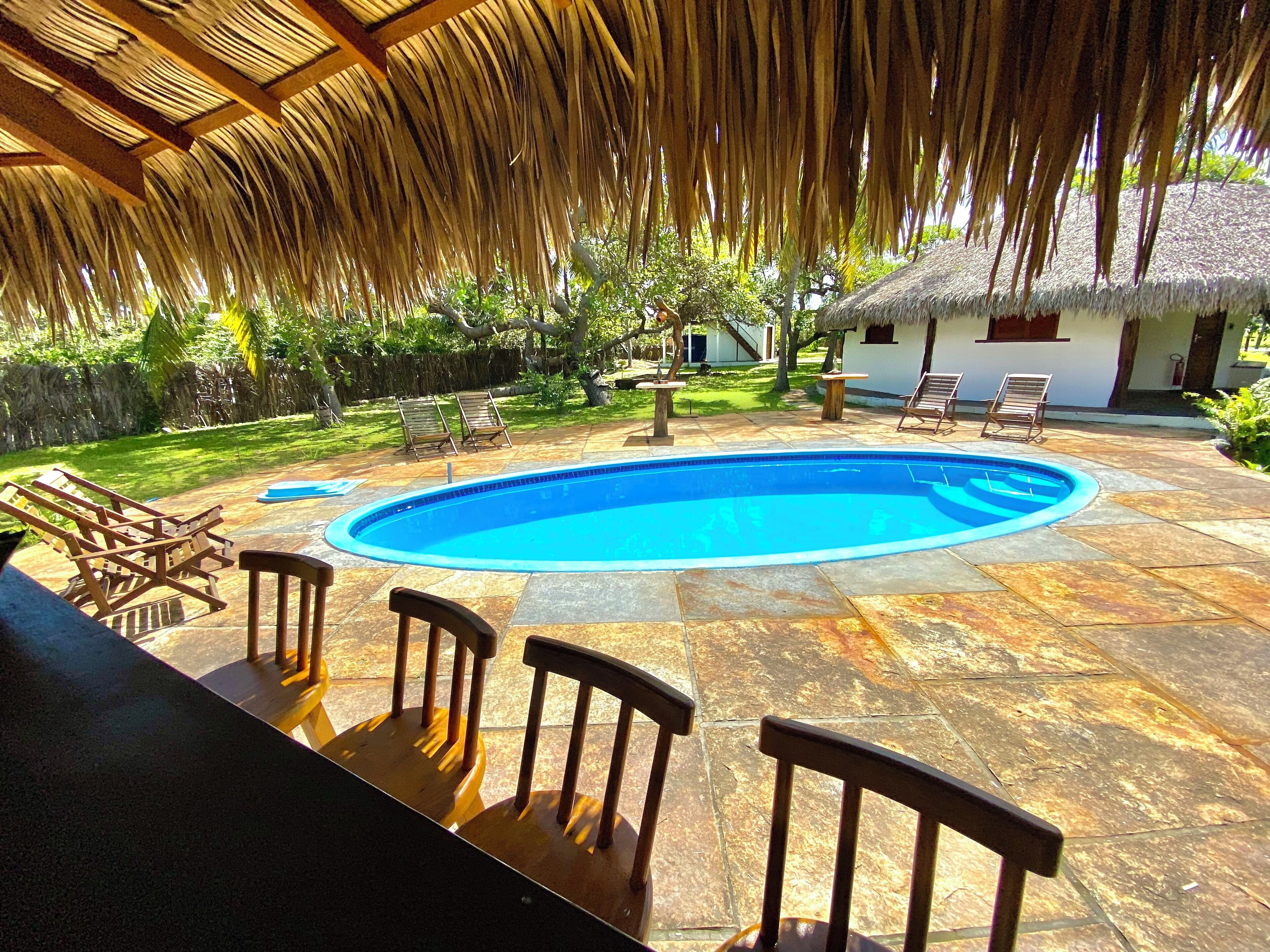 Una piscina al aire libre, sillones reclinables de piscina