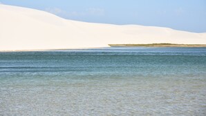 A beach with clear water and sand dunes in the background. - Le Marin Hotel Boutique (Barreirinhas)