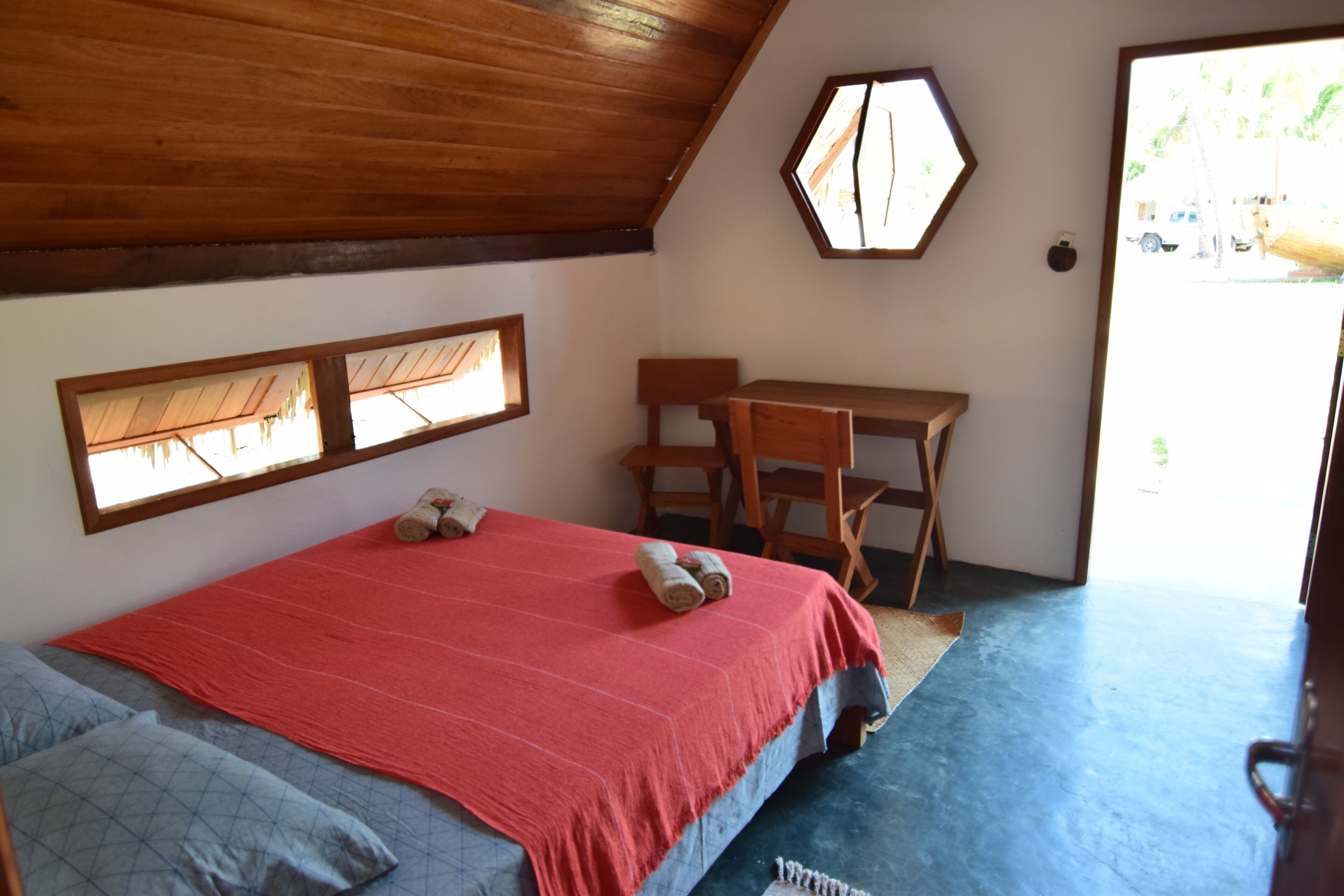 A bedroom with a bed, a desk, and a chair.