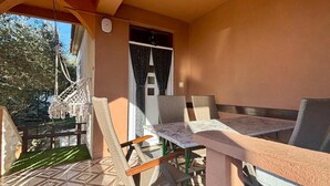 A balcony with a patterned floor, wicker furniture, and a small table. - Apartment in Nin with Terrace, Air condition, WIFI (3718-1) (Nin)