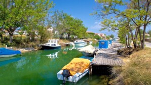 A calm waterway with boats docked along the shore, surrounded by trees and buildings in the background. - Apartment in Nin with Terrace, Air condition, WIFI (3718-1) (Nin)