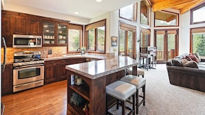 Una cocina amplia con armarios de madera, una isla grande y vistas al exterior.