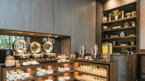 Een buffetgedeelte met meerdere aaneenschakeling van opserfvoorzieningen, glaswerk en decoratieve objecten op planken.