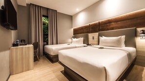 Een moderne hotelkamer met twee bedden, een bureau en een televisie.