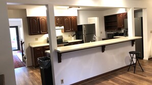 Una cocina moderna con armarios de madera, un refrigerador de acero inoxidable y una encimera amplia.