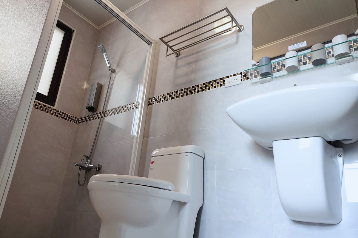 Un bagno moderno con doccia, WC e lavandino.