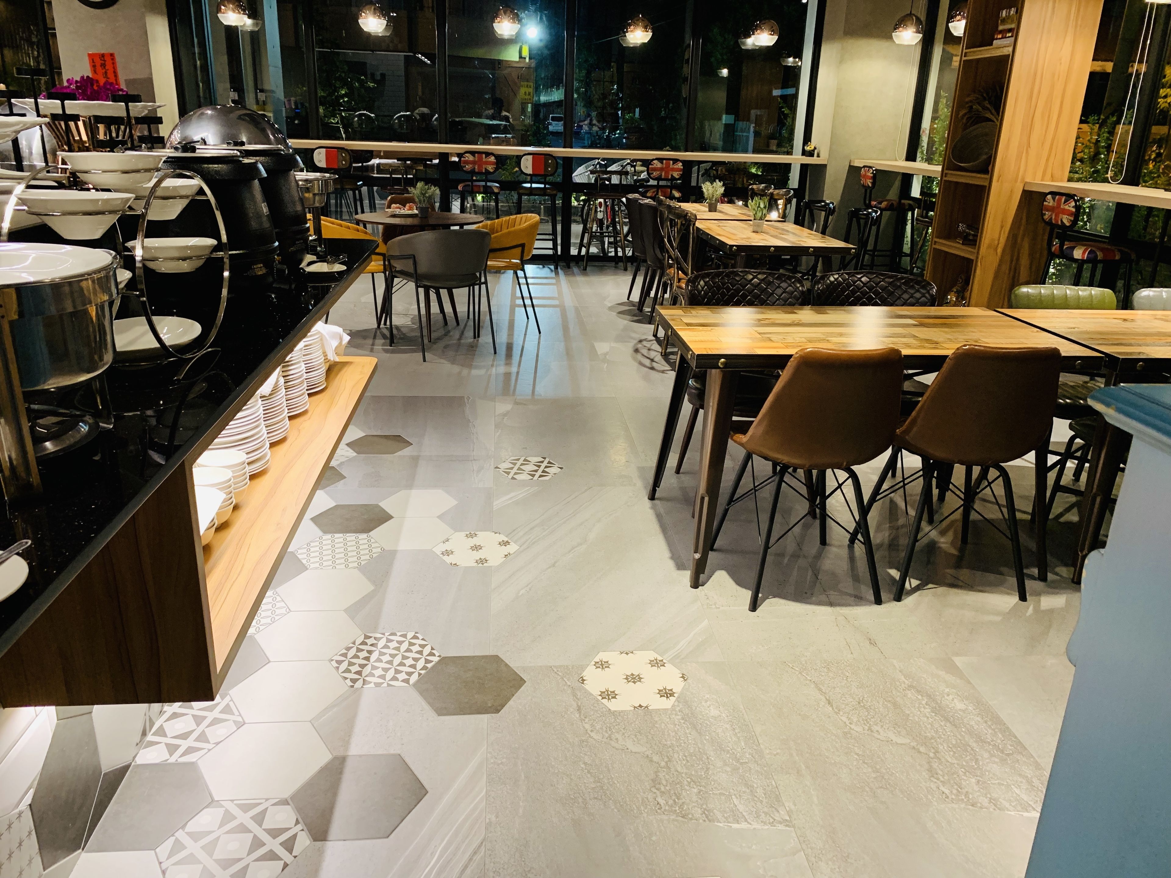 A restaurant with hexagonal patterned flooring, wooden tables, and chairs.