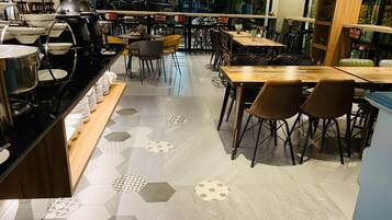 A restaurant with hexagonal patterned flooring, wooden tables, and chairs.